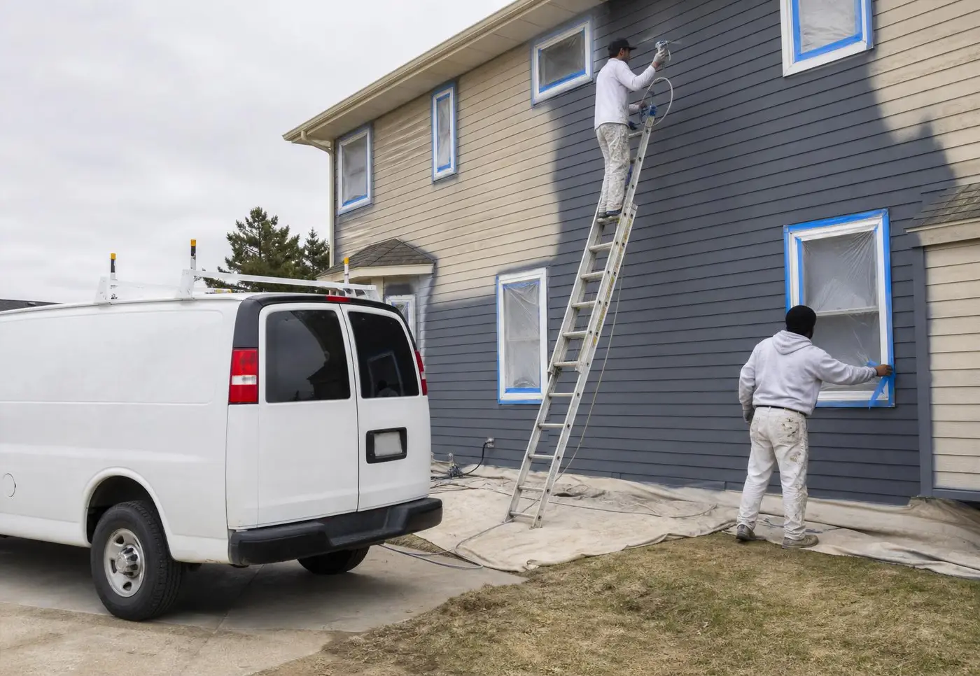 Professional exterior painter applying premium coating to vinyl siding